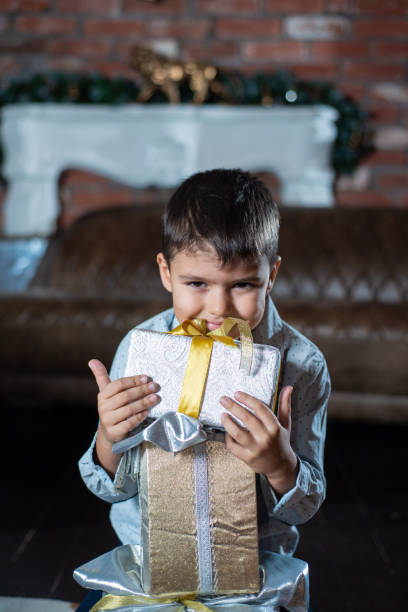 istock little boy with a gift box on the floor. Merry Christmas 1074889984