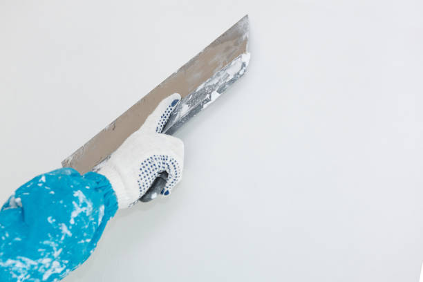 istock Hand with a spatula in the process of leveling the raw plaster. 1074894338