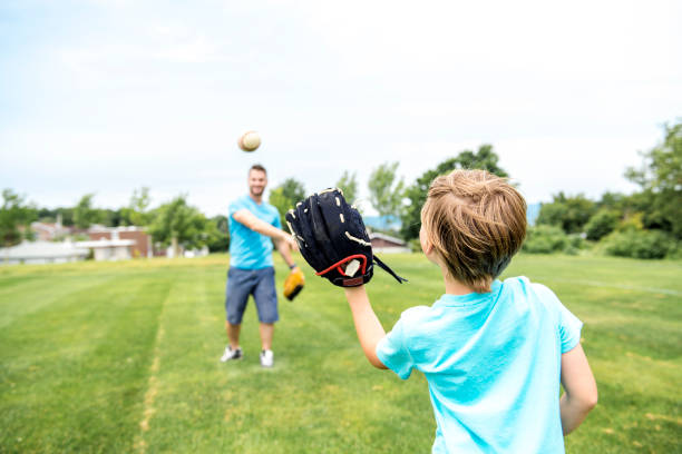 그의 작은 귀여운 태양 잘생긴 아빠 녹색 잔디 잔디밭에 야구를 연주하는 - boys playing baseball 뉴스 사진 이미지