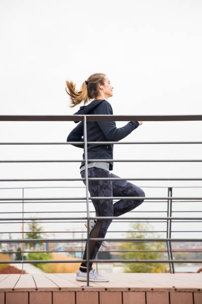 istock Young woman workout by fence 1074907080