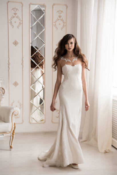 istock Slender bride by the window in a wedding dress. 1074910488