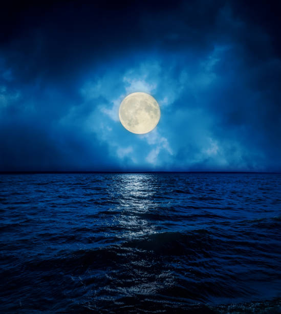 istock full super moon in dramatic clouds over dark water 1074910546
