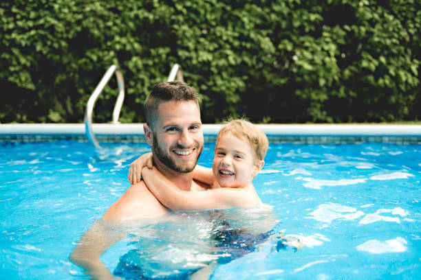 istock Cute little boy learning to swim with parents in pool 1074915242