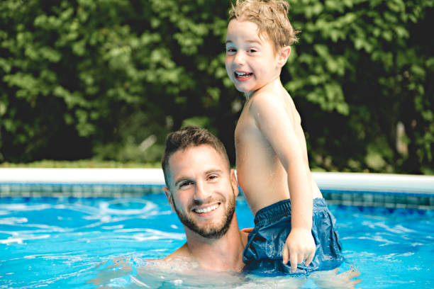 istock Cute little boy having fun with parents in pool 1074915350