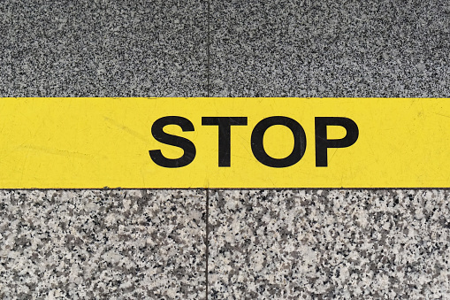 Stop sign yellow line at marble floor warning