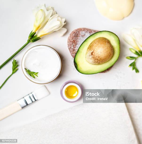 Avocado And Jar Of Cream Oil Lily Flowers And Sea Salt Soap White Towel On A White Background Avocado Skin Care Facial Mask Facial Treatment Concept Flat Lay Top View Copy Space Blogging Stock Photo - Download Image Now