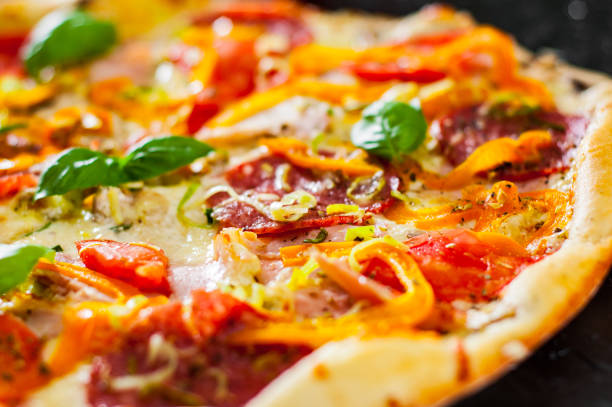 istock Pizza with Mozzarella cheese, Ham, Tomatoes, salami, pepper, pepperoni Spices and Fresh Basil. Italian pizza. 1074926488