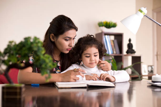 istock Mother helping daughter with homework 1074933180