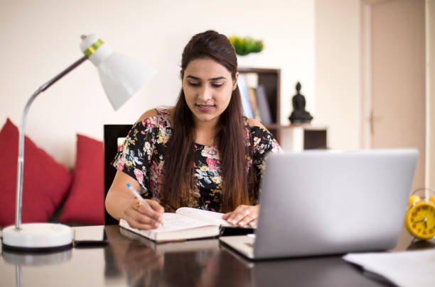 istock Woman writing book at home 1074933600