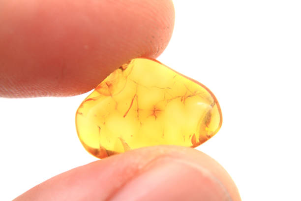 istock amber stone in human fingers 1074936396