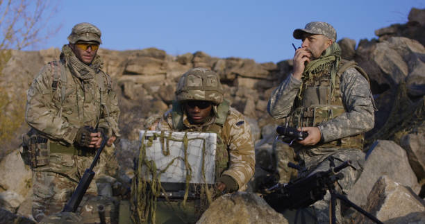 вооруженный афро-американский солдат, глядя на компьютер - mountain range audio стоковые фото и изображения