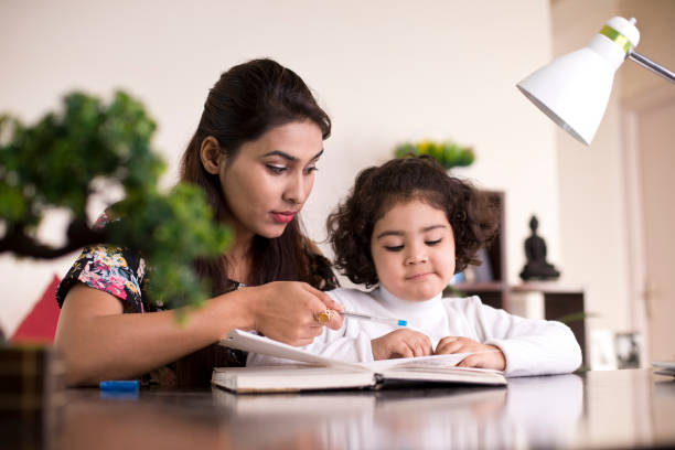 istock Mother helping daughter with homework 1074937498