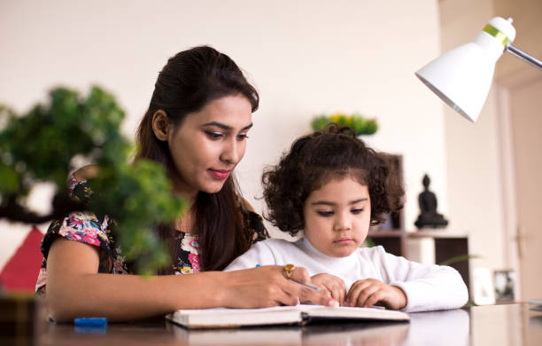 istock Mother helping daughter with homework 1074937862