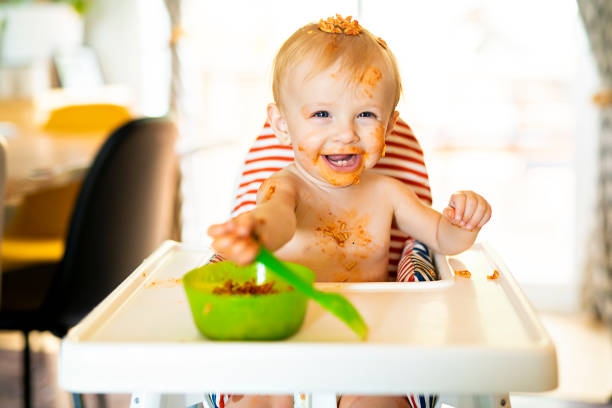 istock Little baby eating spaghetti dinner and making a mess 1074943146