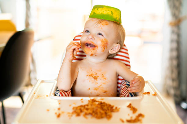スパゲッティ ディナーを食べると混乱を作る小さな赤ちゃん - child eating pasta spaghetti ストックフォトと画像