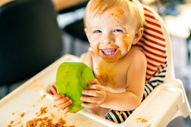 istock Little baby eating spaghetti dinner and making a mess 1074943240