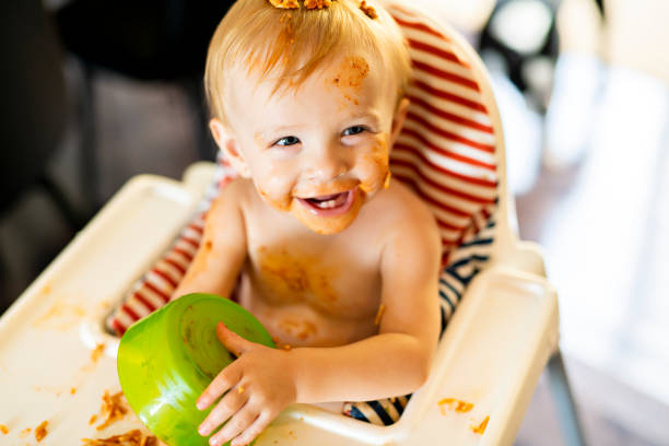 istock Little baby eating spaghetti dinner and making a mess 1074943270