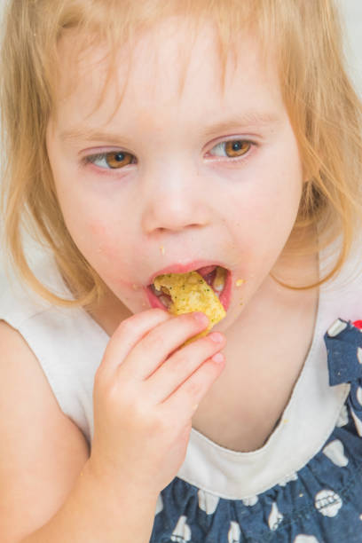istock girl, baby eat potato chips 1074944562