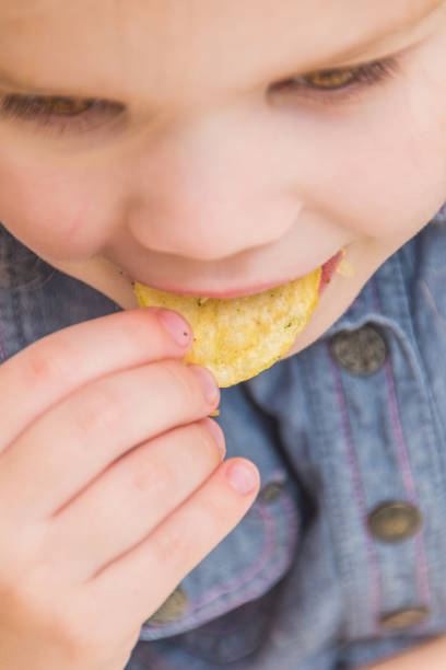 istock girl, baby eat potato chips 1074944958