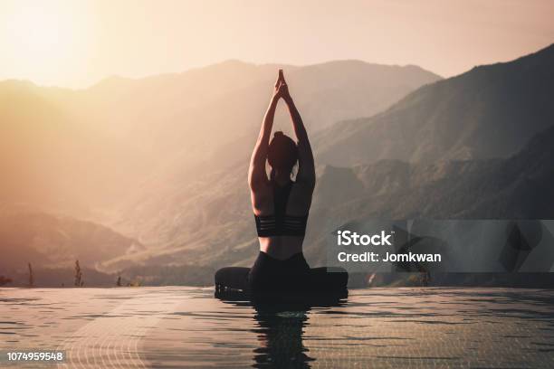 Beautiful Attractive Asian Woman Practice Yoga Lotus Pose On The Pool Above The Mountain Peak In The Morning In Front Of Beautiful Nature Viewsfeel So Comfortable And Relax In Holidaywarm Tone Stock Photo - Download Image Now