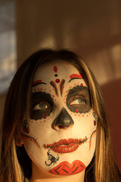 istock A girl with make-up skeleton on her face. Halloween. 1074960016