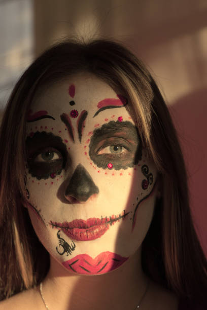istock A girl with make-up skeleton on her face. Halloween. 1074960024