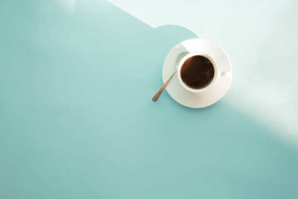 Cup of steaming coffee on seafoam green table, top view Abstract photo of hot espresso drink on pale blue-green background spume stock pictures, royalty-free photos & images