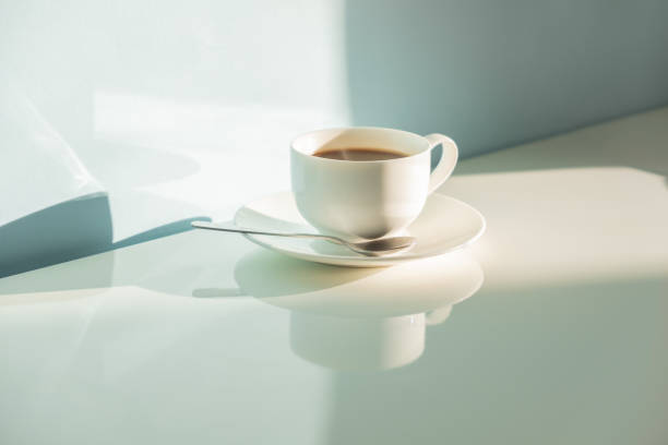 istock Cup of steaming coffee on seafoam green background in bright sunlight 1074962476