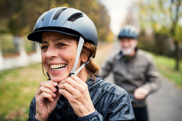 istock Active senior couple with electrobikes standing outdoors on a road in nature. 1074967002