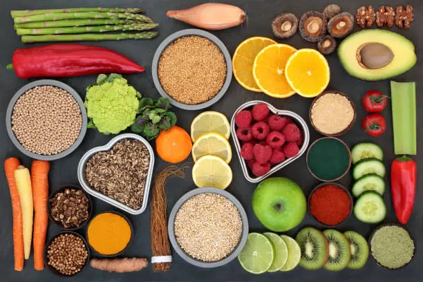 Liver detox diet health food concept with fruit, vegetables, herbal medicine, seeds, nuts, grains, cereals, and supplement powders. High in antioxidants, omega 3, vitamins &  dietary fibre. Top view on slate.