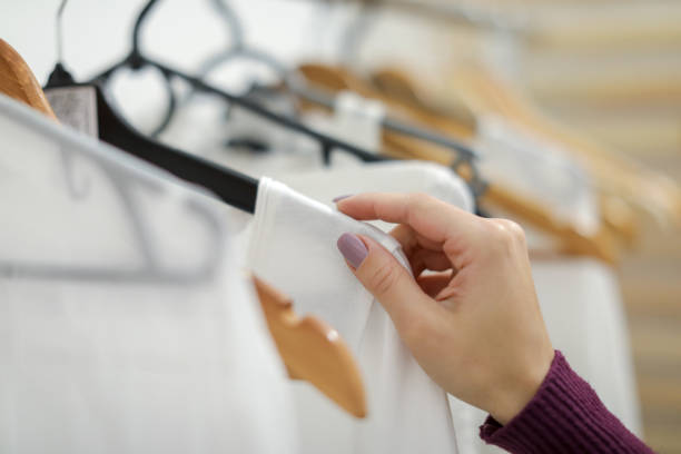 istock Women's white clothing on hanger in store 1074976780