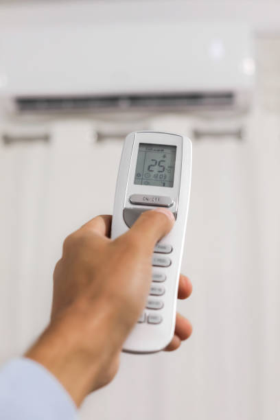 istock hand holds a remote control of air conditioner 1074976862
