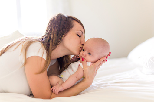 A Portrait of mother with her 3 month old baby in bedroom