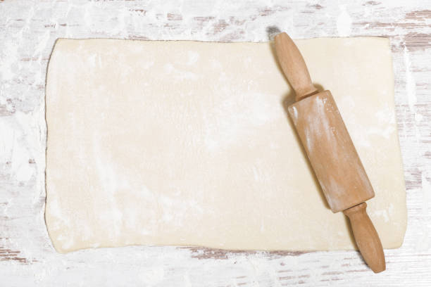 istock the sheet of dough and rolling pin on the table, top view 1074982600