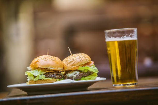 Delicious Burgers Served With Fresh Cold Glass Of Beer At Sunbathed Restaurant Garden