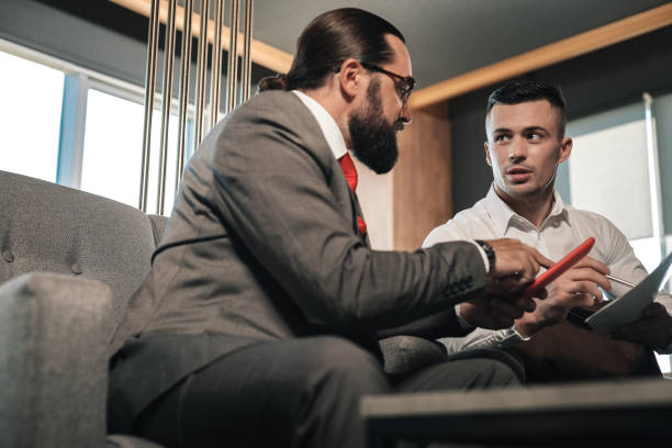 istock Boss wearing suit giving some instructions to his employee 1074986128