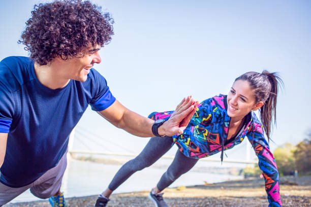 istock sporty couple giving high five to each other while doing push up together 1074986586