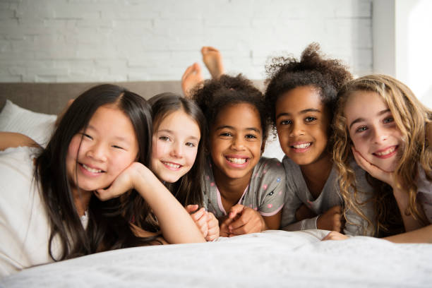 istock large group of her friends taking goog time on bed 1074986830
