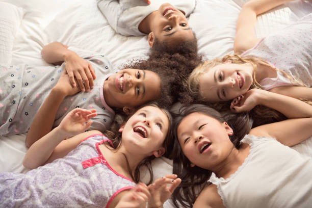 istock large group of her friends taking goog time on bed 1074986962