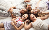 large group of her friends taking goog time on bed