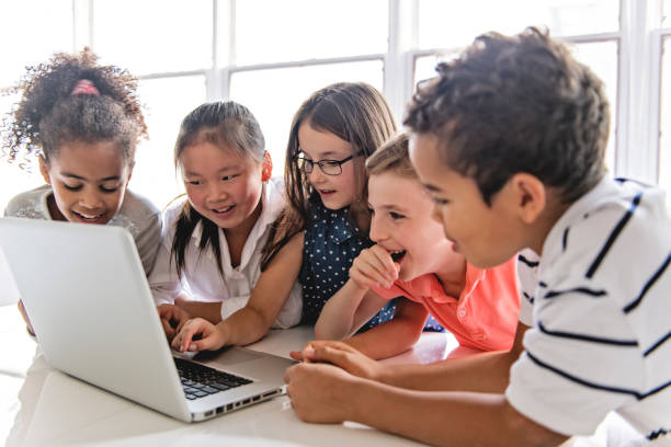 istock Group of curious children watching stuff on the laptop screen 1074987248