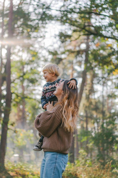 istock Mother playing with little son in forest in autumn 1074988722