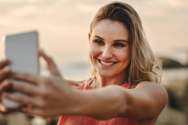 istock Woman taking selfie standing at the beach 1074988728