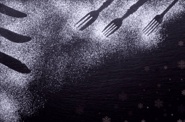istock Black and white background design with figures of kitchen flatware on the snow or flour 1074994902