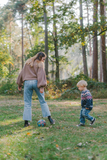 istock Little boy playing soccer  with mom in forest 1074995334