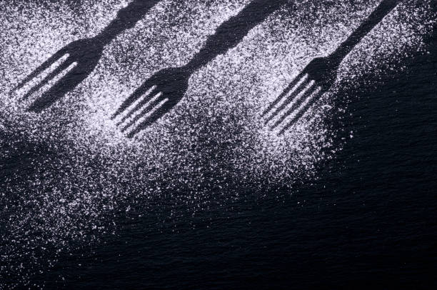 istock Black and white background design with figures of kitchen flatware on the snow or flour 1074996734