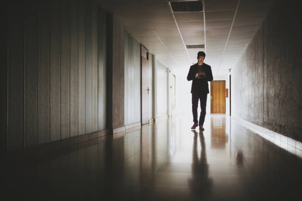istock Handsome business person walking while looking at a digital tablet 1074997594