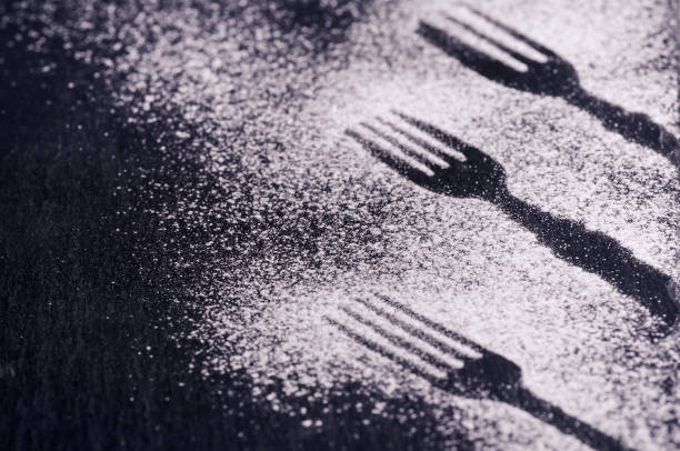 Black and white background design with figures of kitchen flatware on the snow or flour