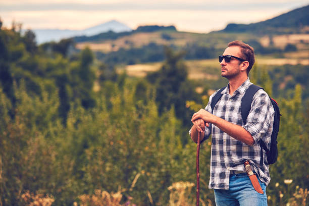 istock Hiker posing with knife on the belt in a meadow. 1075003794