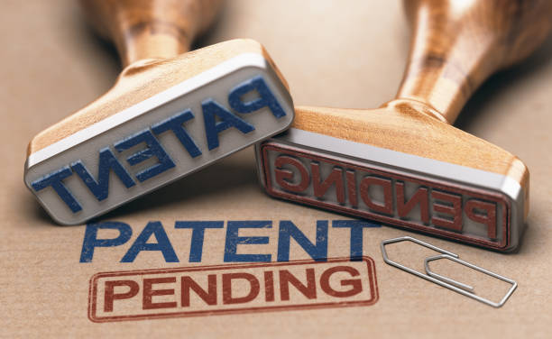 Patent Pending Concept Two rubber stamps with the words patent and pending over brown paper background. Intellectual property concept. 3D illustration. intellectual property photos stock pictures, royalty-free photos & images